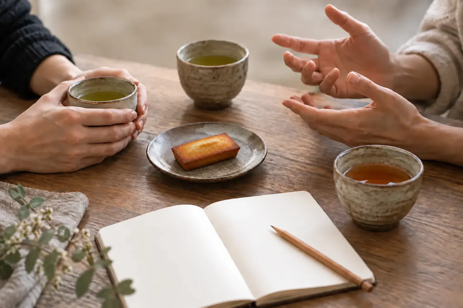 湯呑みとお菓子を囲んで話す二人の手元